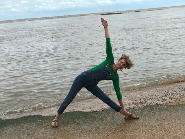 Yoga on the beach - practicing Trikonasana
